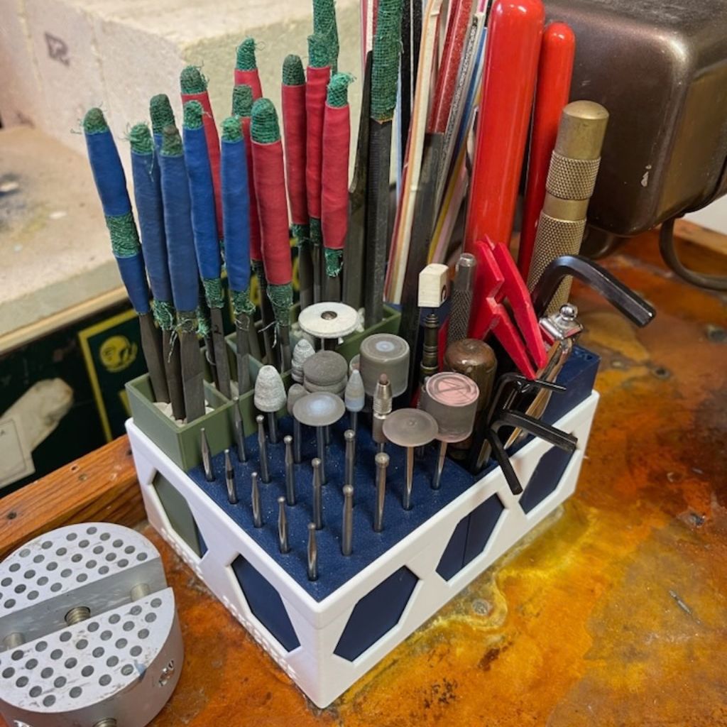 Close-up of AJ Newell’s SlipFit finishing station holding burrs, wheels, and hand tools